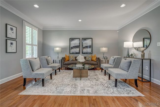 rich hardwood floors, detailed crown molding, classic wainscoting, and stately architectural columns. | Image 9