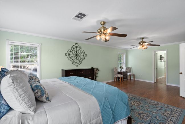 The Texas-sized primary suite is a true retreat with French door entry, crown molding, and sitting area. | Image 26