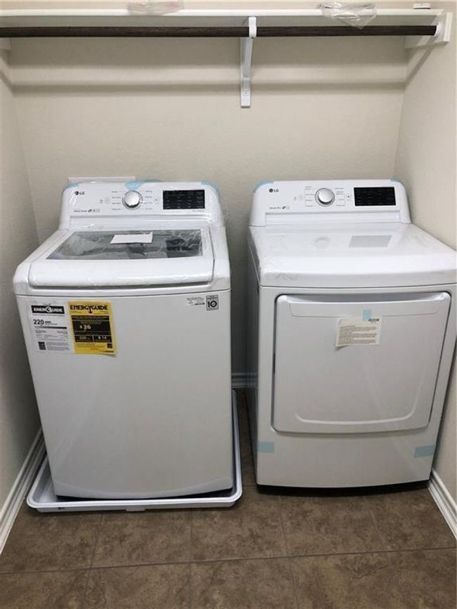 Laundry room featuring washer and dryer and dark tile patterned flooring | Image 23