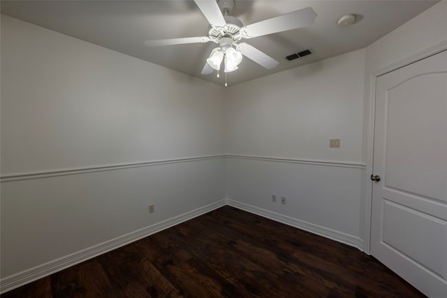 Spare room with ceiling fan, baseboards, dark wood-style flooring, and visible vents | Image 28