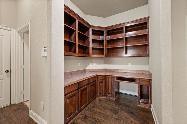 Unfurnished office with built in desk and dark wood-type flooring | Image 16