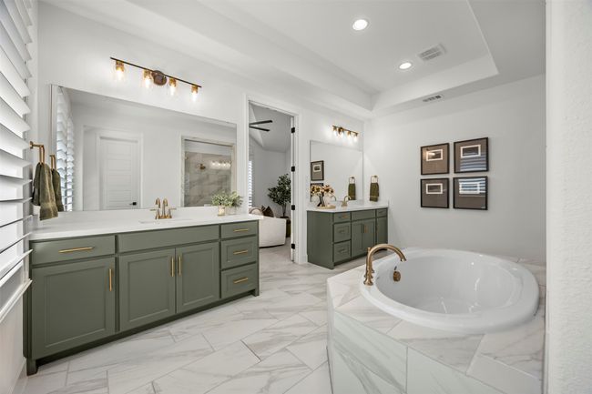 Bathroom featuring two vanities, a garden tub, tiled shower, marble look tiles, and recessed lighting | Image 22