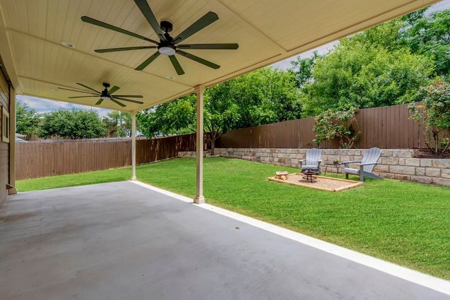 Fenced backyard featuring a ceiling fan and a patio area | Image 27