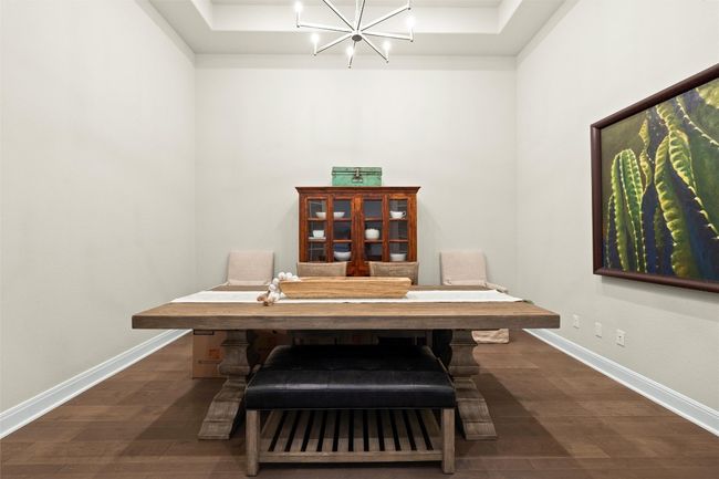 Dining room with a chandelier, a raised ceiling, and dark wood finished floors | Image 9