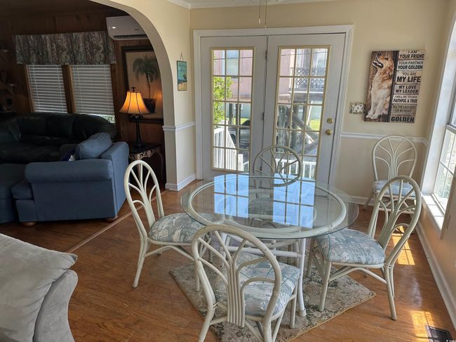 Dining space featuring arched walkways, a wall mounted air conditioner, and wood finished floors | Image 14