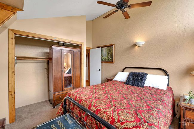 Carpeted bedroom featuring lofted ceiling, a ceiling fan, a textured wall, and a closet | Image 32