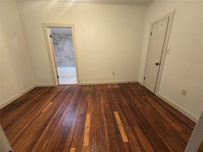 Spare room with dark wood-style flooring and baseboards | Image 14