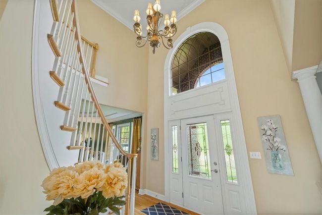 Enter through the beveled glass front door into an impressive two-story foyer with hardwood flooring which continues throughout the entire main level. | Image 5