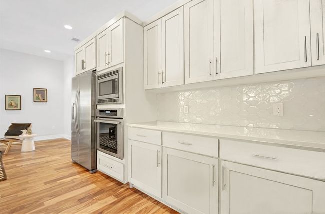 Kitchen with light countertops, appliances with stainless steel finishes, tasteful backsplash, and light wood-style floors | Image 9