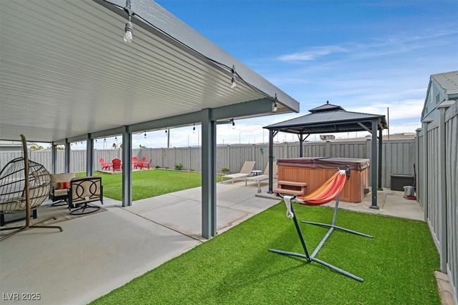 View of patio featuring a gazebo, a fenced backyard, and a hot tub | Image 32