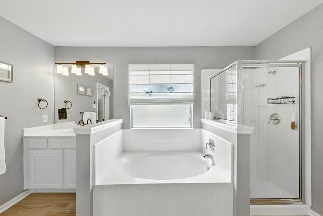 Full bathroom with a garden tub, a stall shower, vanity, and wood finished floors | Image 21