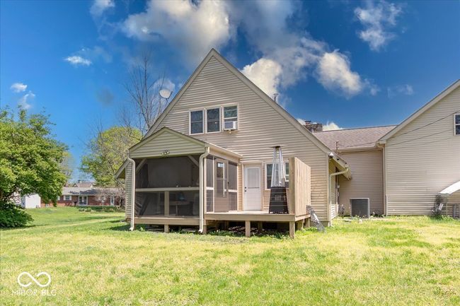 back view of home with a covered sitting area and a deck that is off the master bedroom | Image 5