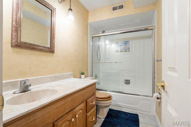 Full bathroom with vanity, bath / shower combo with glass door, and tile patterned flooring | Image 18