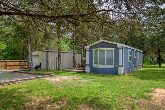 View of outdoor structure featuring an outbuilding and view of scattered trees | Image 12