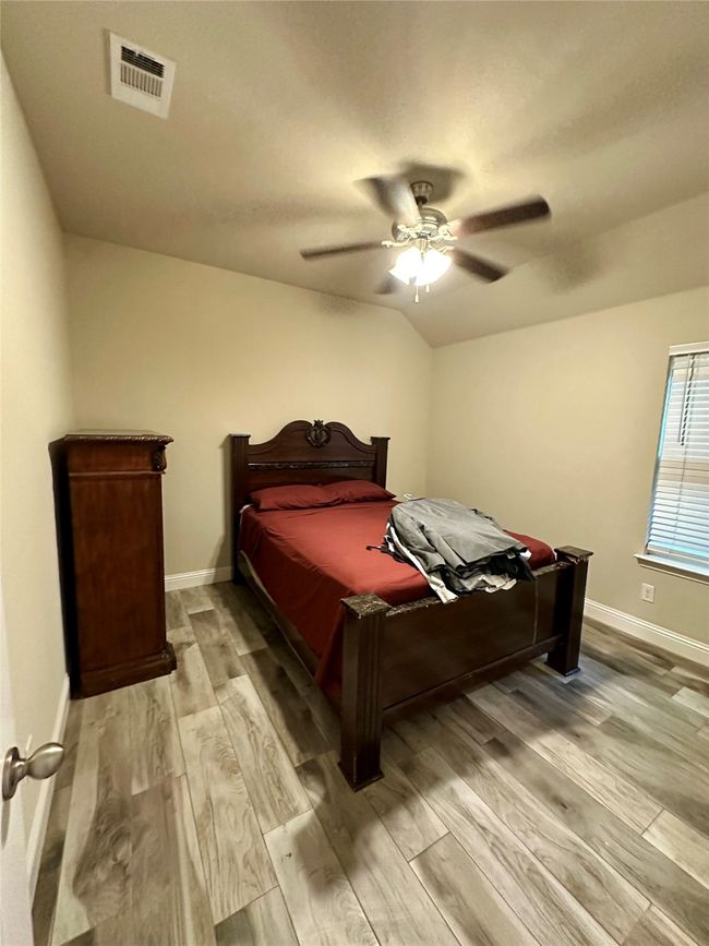Bedroom with light wood-style flooring, a ceiling fan, and vaulted ceiling | Image 22