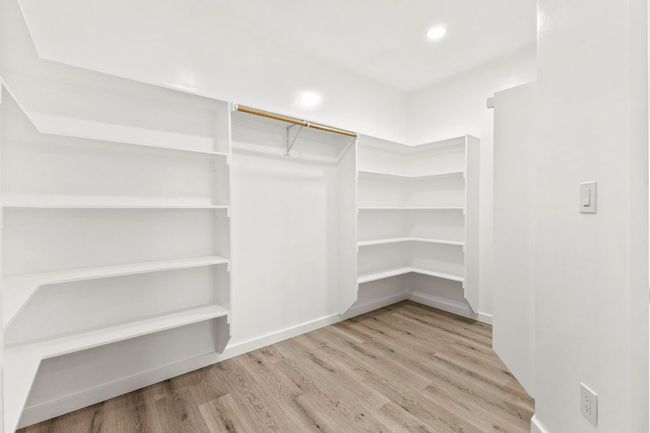 Huge walk in closet with shelves & recessed lighting in the primary closet. | Image 20