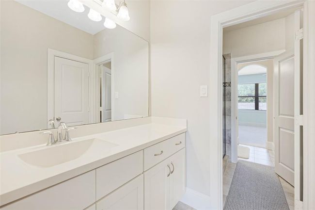 Jack-and-Jill style bathroom features a long vanity with ample storage and neutral finishes. Clean and functional with opportunity to update and personalize. | Image 38
