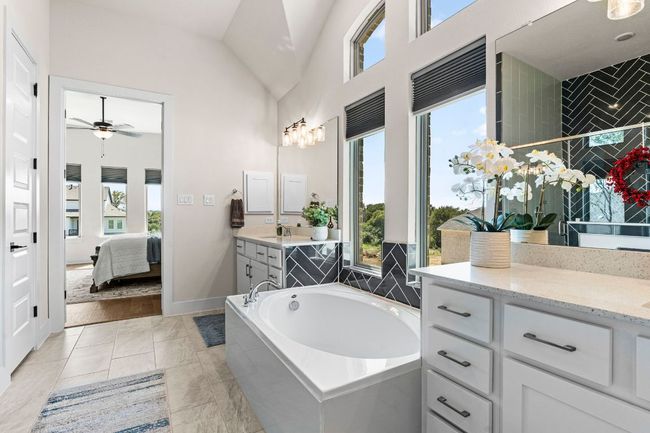Full bath with baseboards, lofted ceiling, ensuite bathroom, a garden tub, and vanity | Image 26
