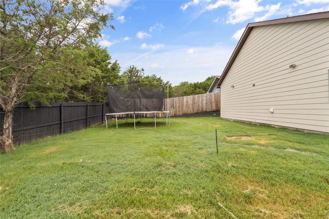 Fenced backyard featuring a trampoline | Image 36