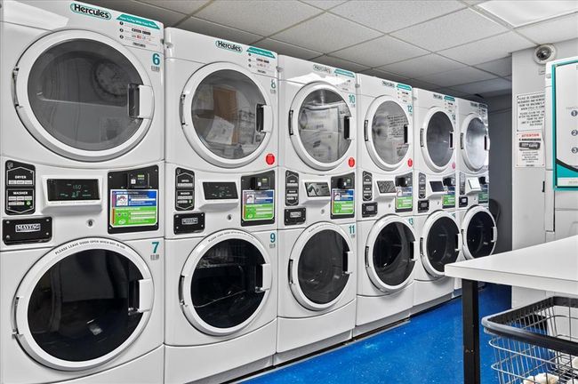 Community laundry room featuring stacked washing machine and dryer and washing machine and dryer | Image 21