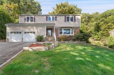 View of front facade with a front yard and a garage | Image 1