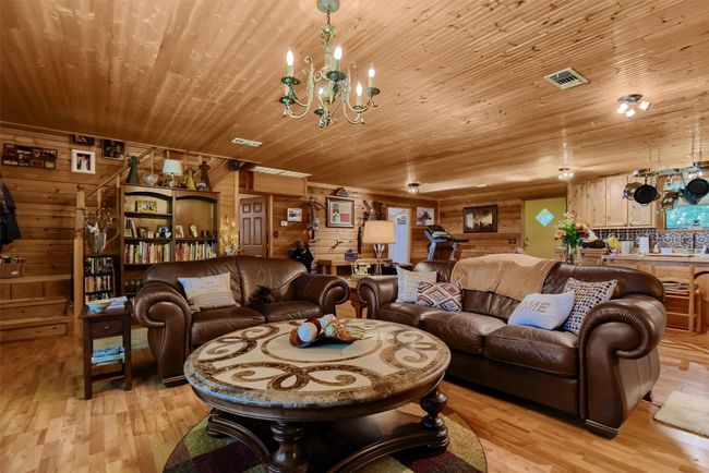 Living room featuring a chandelier, wooden ceiling, light wood finished floors, and visible vents | Image 15