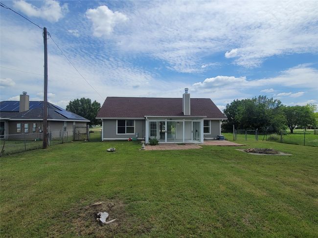 Rear view of house with a patio area, a fire pit, and a chimney | Image 23