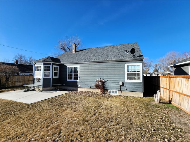 Back of house featuring a patio, a chimney, a shingled roof, and a fenced backyard | Image 7