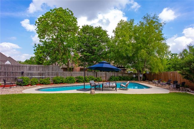 View of swimming pool with a fenced in pool, a lawn, a fenced backyard, and a patio | Image 30