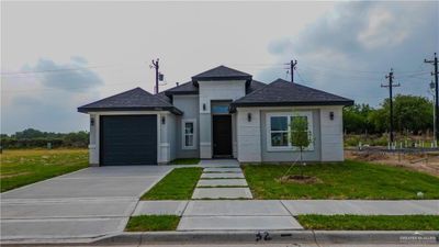 View of front of property with a front yard and a garage | Image 1