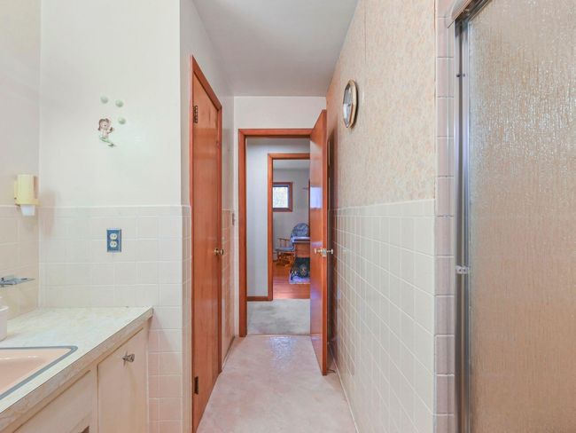 Hallway with tile walls and sink | Image 27