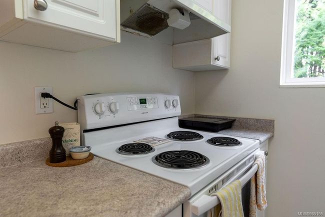 Kitchen featuring white cabinetry, white range with electric stovetop, and exhaust hood | Image 9