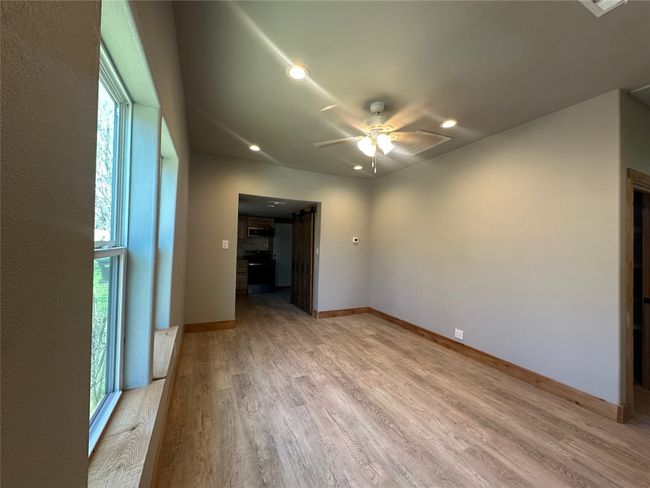 Spare room featuring baseboards, ceiling fan, a healthy amount of sunlight, and light wood-type flooring | Image 11