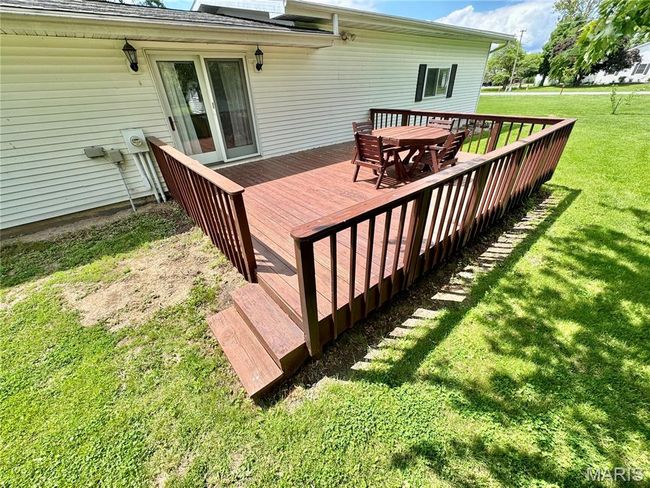 Wooden deck featuring a lawn and outdoor dining space | Image 8
