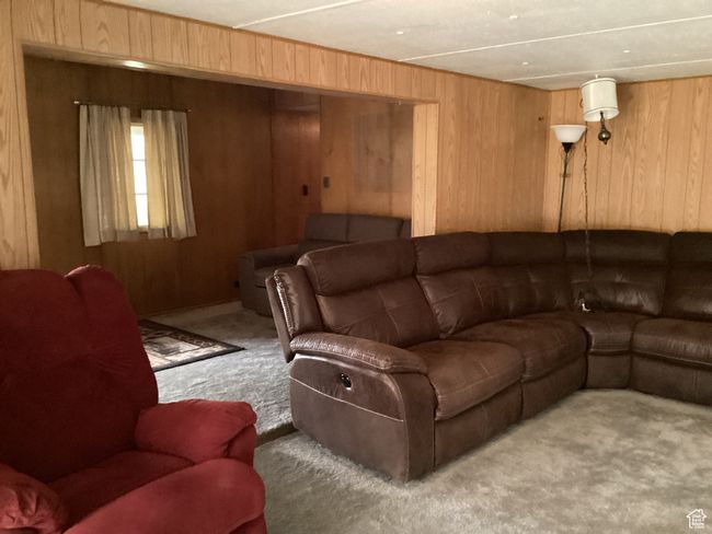 Living room with carpet floors and wood walls | Image 11