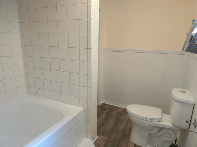 Bathroom with a bathing tub, hardwood / wood-style floors, and toilet | Image 16