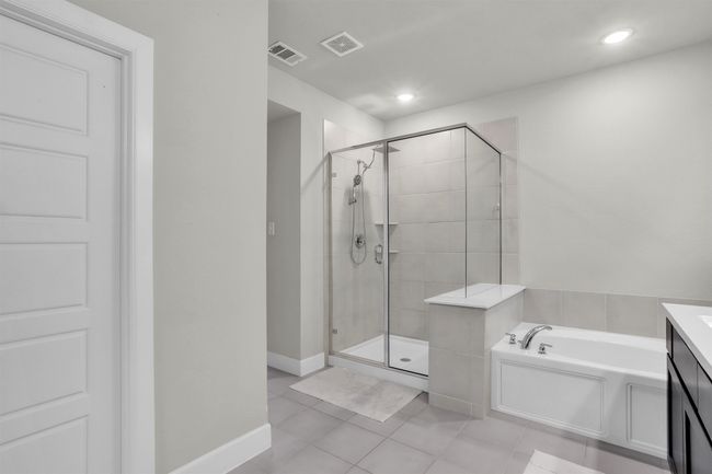 Bathroom featuring tile patterned flooring, a bath, visible vents, and a stall shower | Image 17