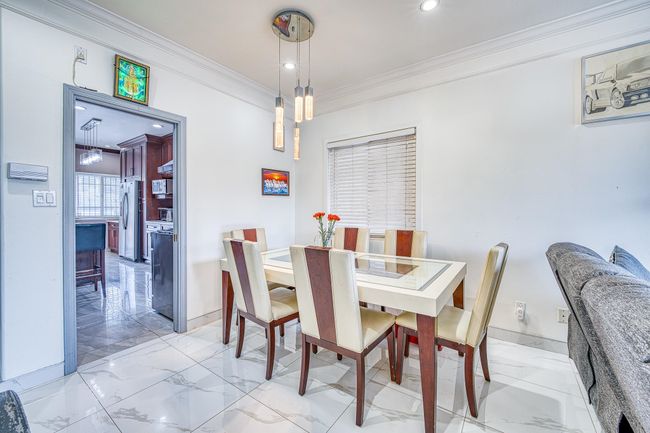 Dining area featuring ornamental molding, light marble finish floors, and recessed lighting | Image 8