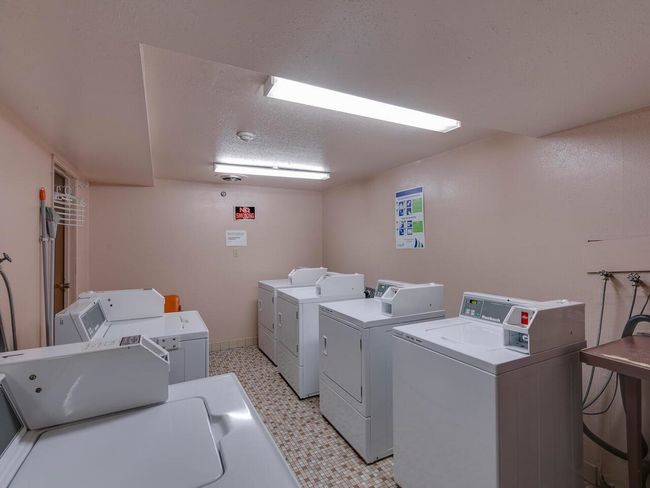 Community laundry room featuring washing machine and dryer, light floors, and a textured ceiling | Image 20