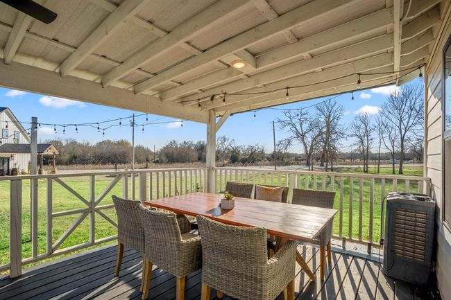 Enjoy outdoor dining and relaxed conversation on the covered porch—with string lights adding a warm, welcoming touch. | Image 26