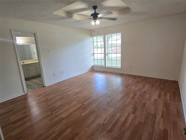 Spare room featuring ceiling fan, a textured ceiling, and dark wood-style flooring | Image 11
