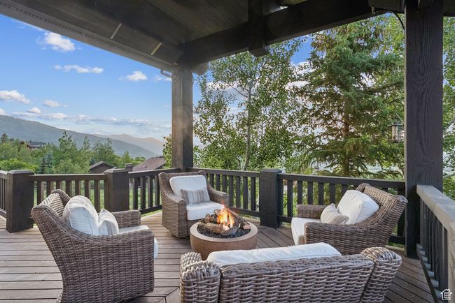 Wooden deck featuring an outdoor fire pit and a mountain view | Image 33