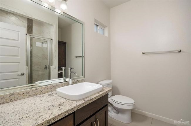 Bathroom with vanity, tile patterned flooring, a shower with shower door, and toilet | Image 8