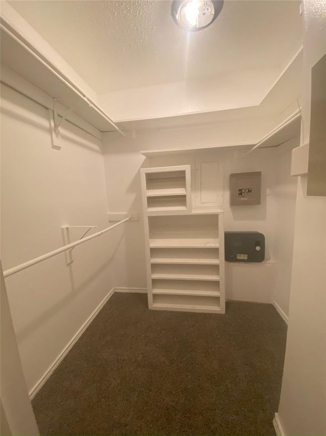 Walk in closet featuring dark colored carpet | Image 6