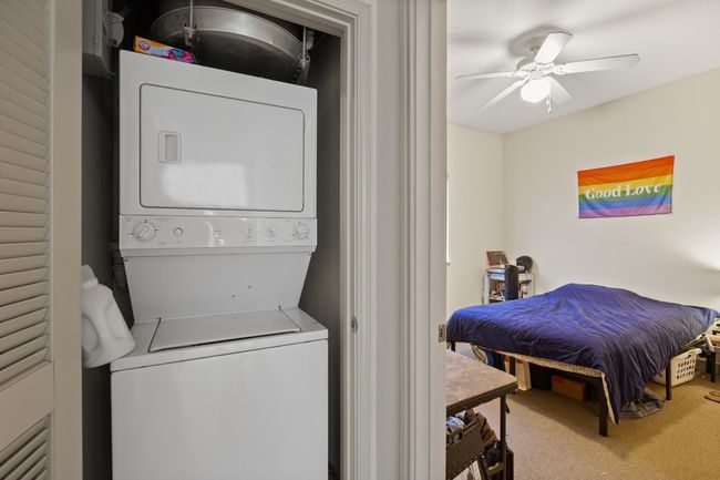 Washroom with stacked washer / drying machine, carpet flooring, and a ceiling fan | Image 8