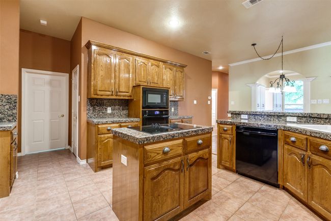 View of kitchen looking at door to pantry and laundry room. | Image 15