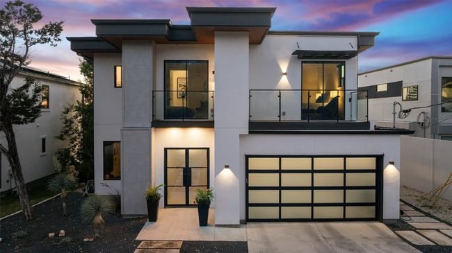 Contemporary home featuring stucco siding, concrete driveway, a garage, and a balcony | Image 23
