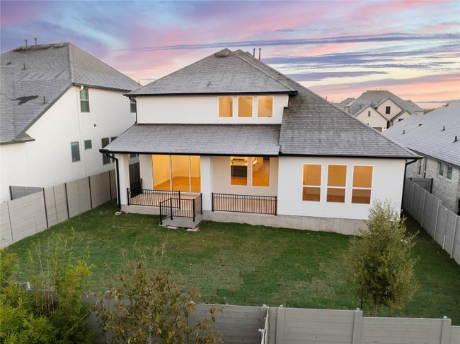 Back of house at dusk with a shingled roof, a fenced backyard, and stucco siding | Image 34