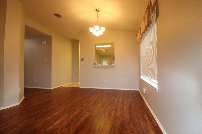 Spare room with dark wood-type flooring and a chandelier | Image 9
