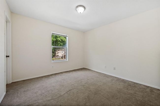 Second bedroom with large window and neutral tones. | Image 20